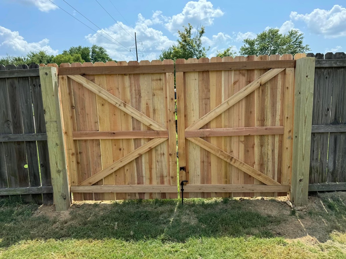 A finished wood double gate with diagonal braces